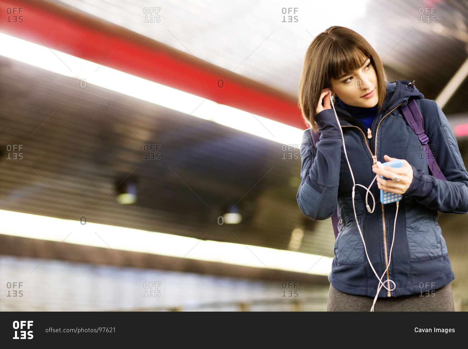 Woman listening to music on a subway platform