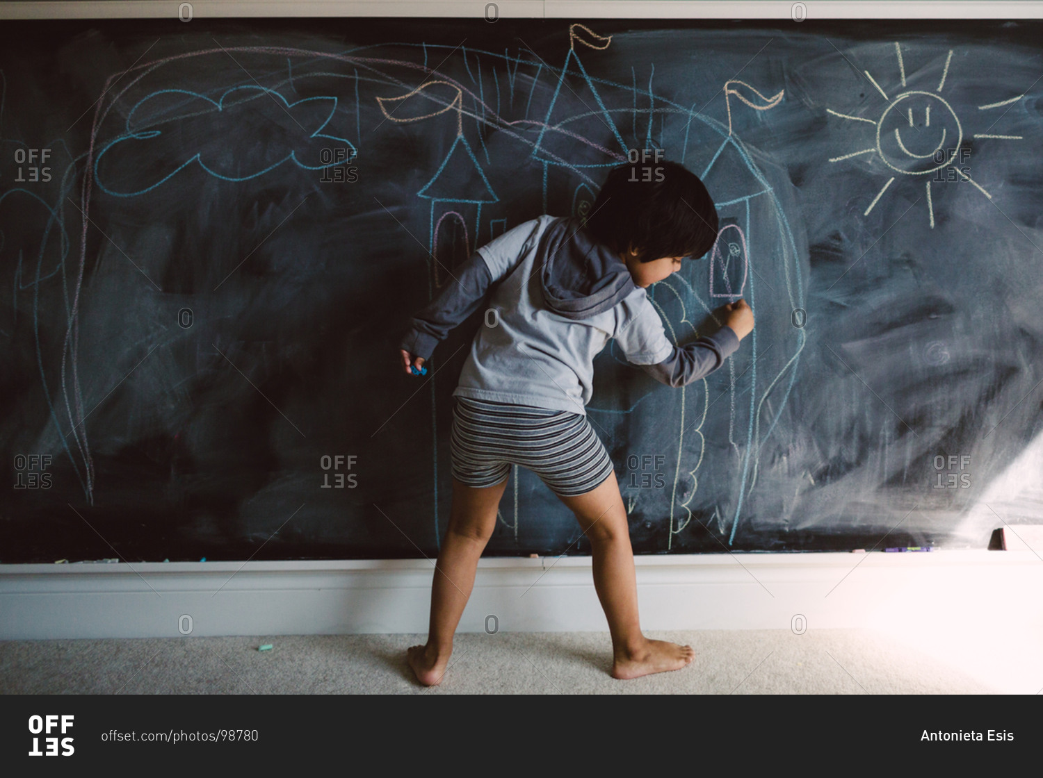 Boy drawing on a chalkboard
