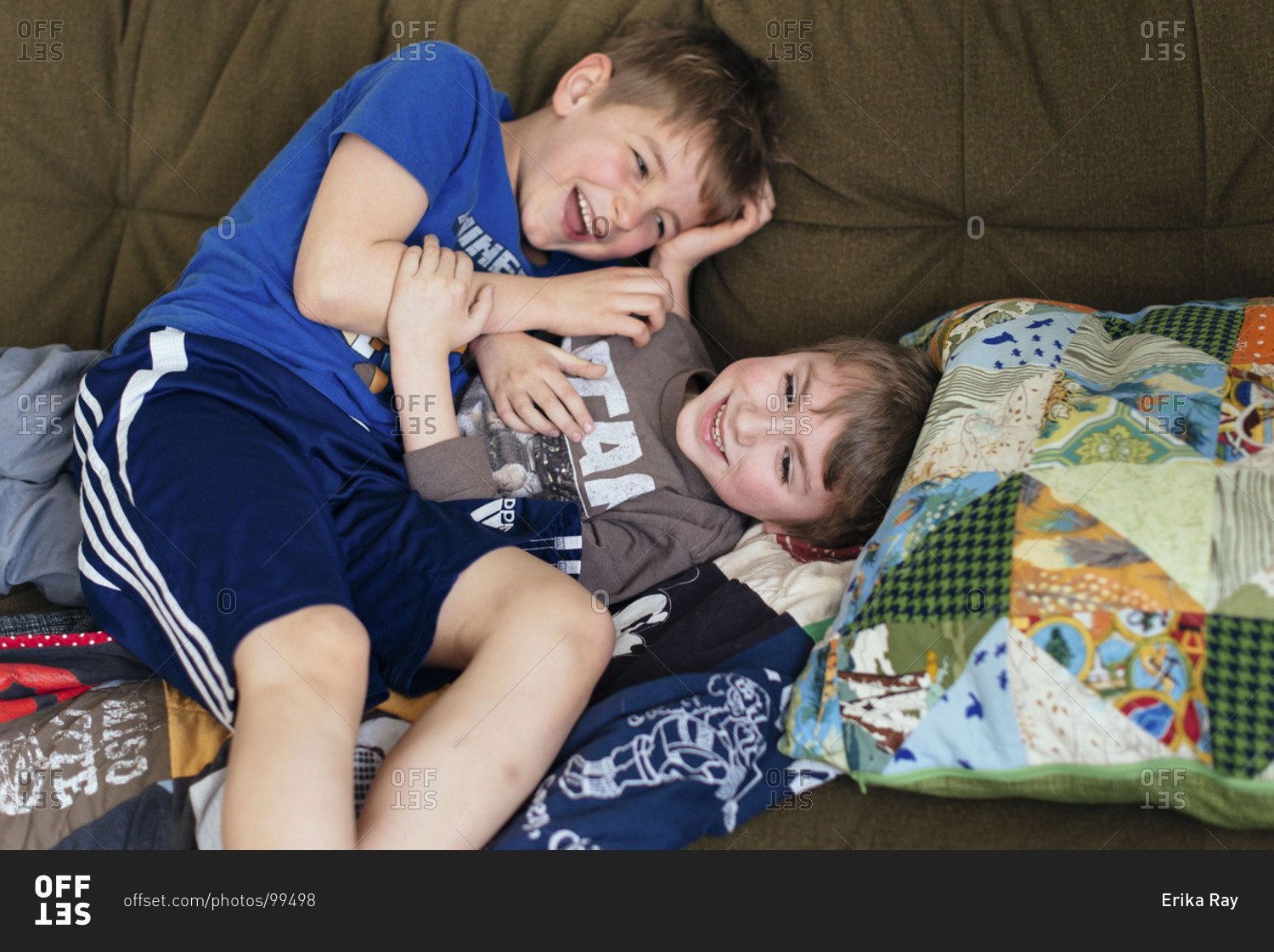 Two boys wrestling on couch