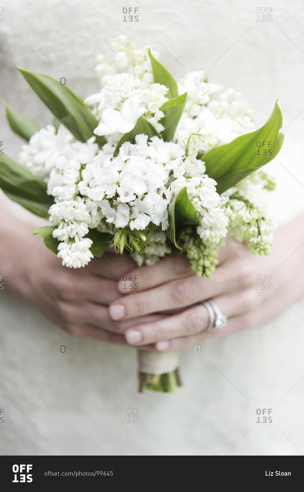 Mid section view of bride holding small bridal bouquet