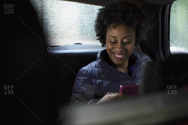 Woman checking her phone in a cab