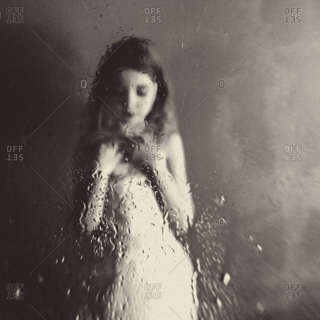 Girl behind a wet glass