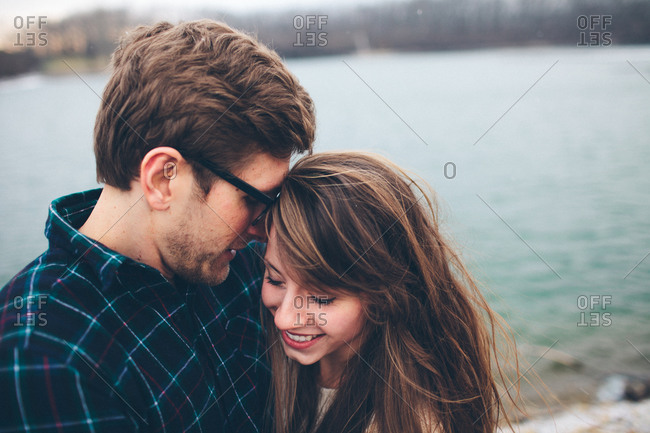 Hipster husband kissing smiling wife near a lake in Colorado stock photo -  OFFSET