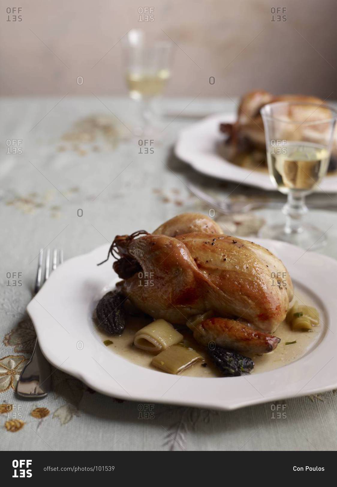 Roasted cornish hens with morels and leeks served on a table