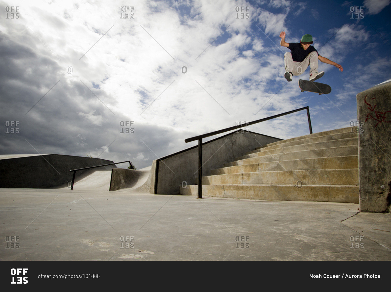 A young skateboarder, kickflips his skateboard over a 7-stair gap at the skatepark in Whitefish, Montana.