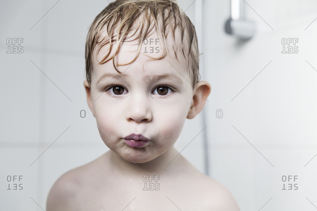 Portrait of little boy with wet hair making a fish face