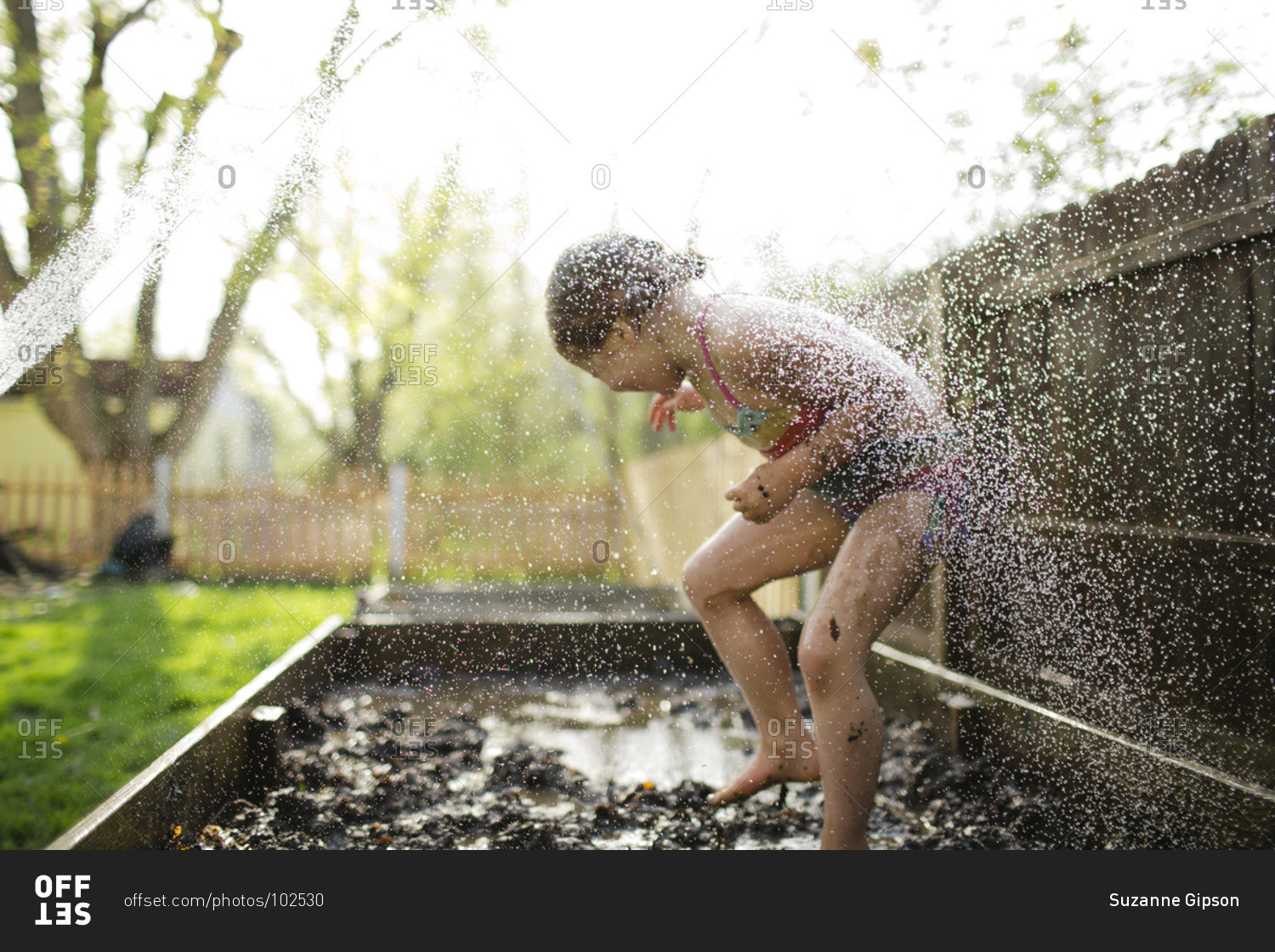 Young girl being splashed in mud box
