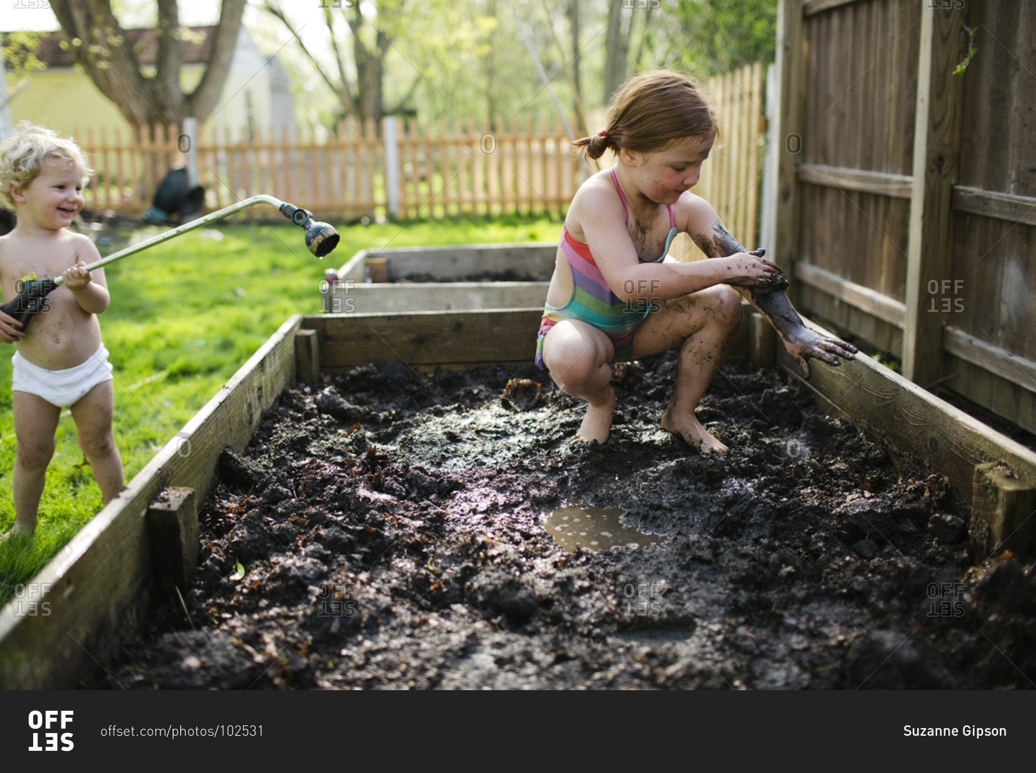 Children playing in the mud stock photo - OFFSET