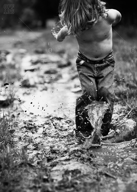 Boy splashing in a puddle
