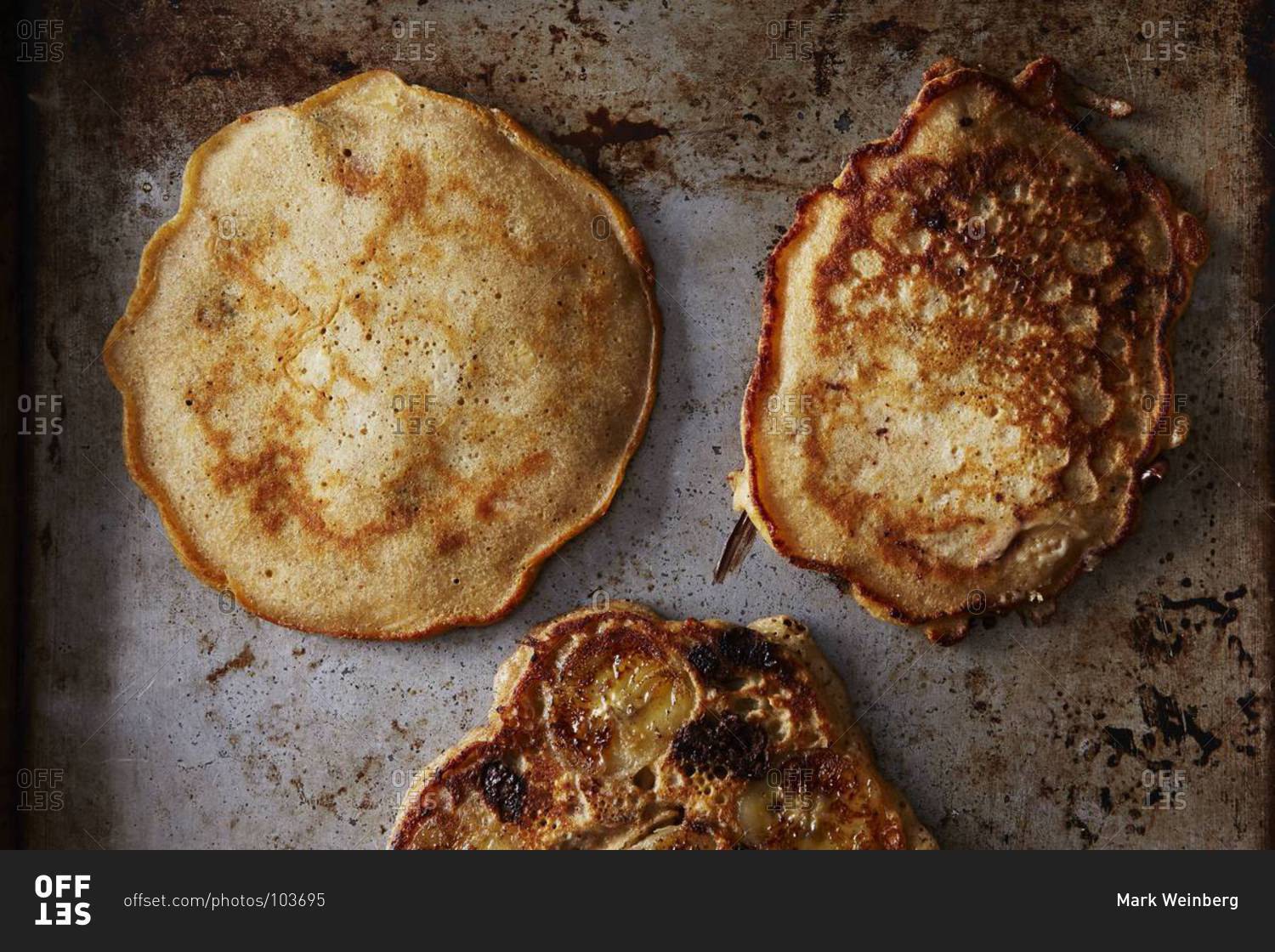 Three cooked pancakes, including one banana pancake