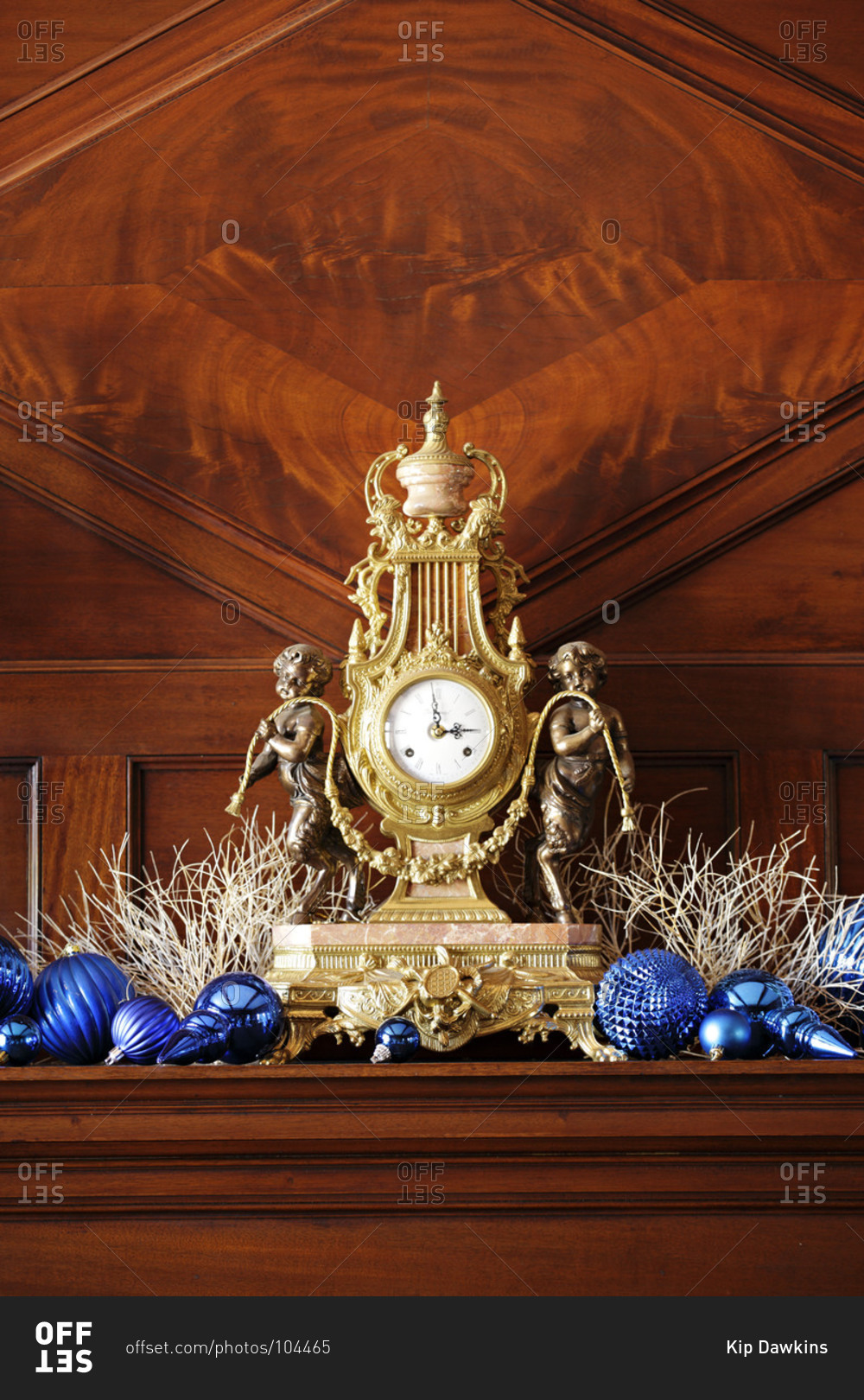 Mantle clock surrounded by ornaments