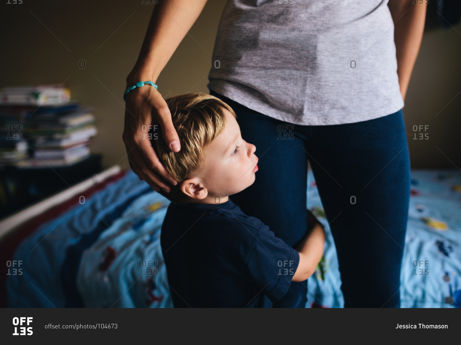 Boy hugging his mother's leg stock photo OFFSET