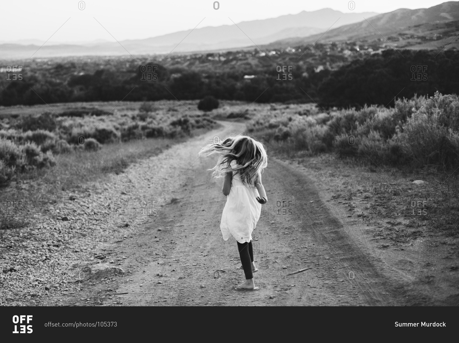 young-girl-walking-in-on-a-dirt-road-in-the-countryside-stock-photo