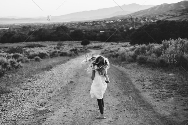 Young girl walking in on a dirt road in the countryside