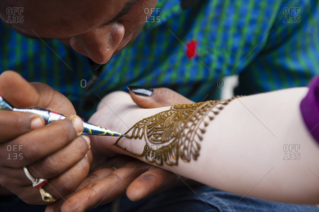 applying henna tattoo on women hands Stock Photo | Adobe Stock