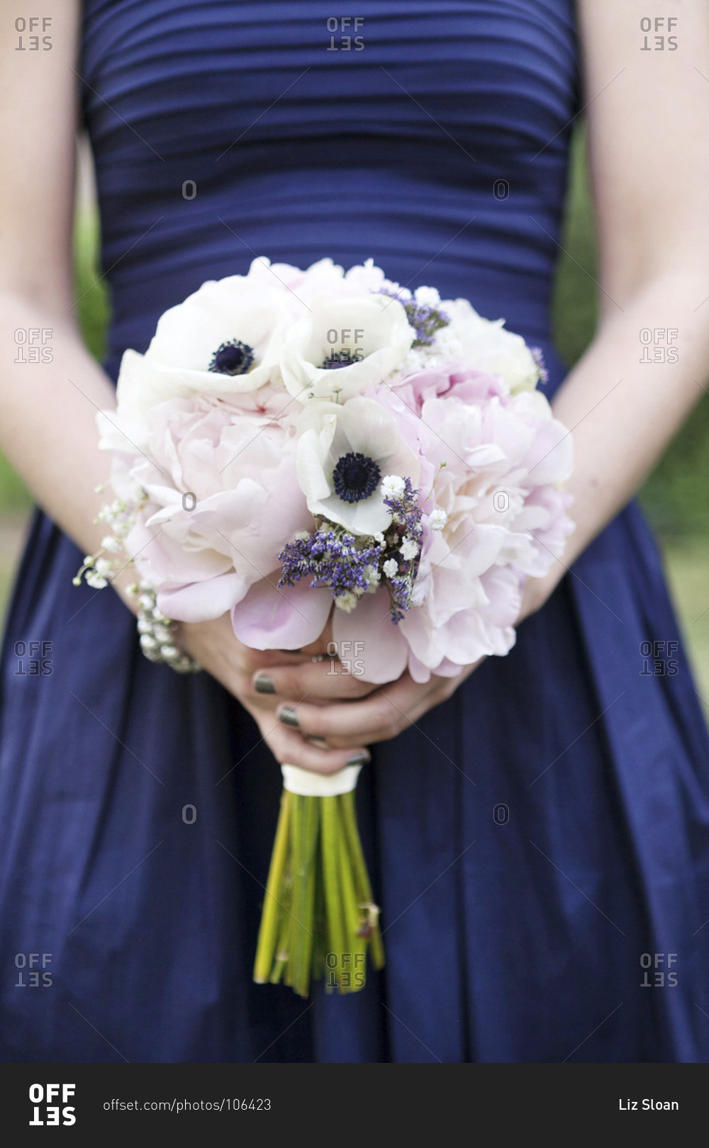 Mid section view of bridesmaid holding a pale pink and white bouquet
