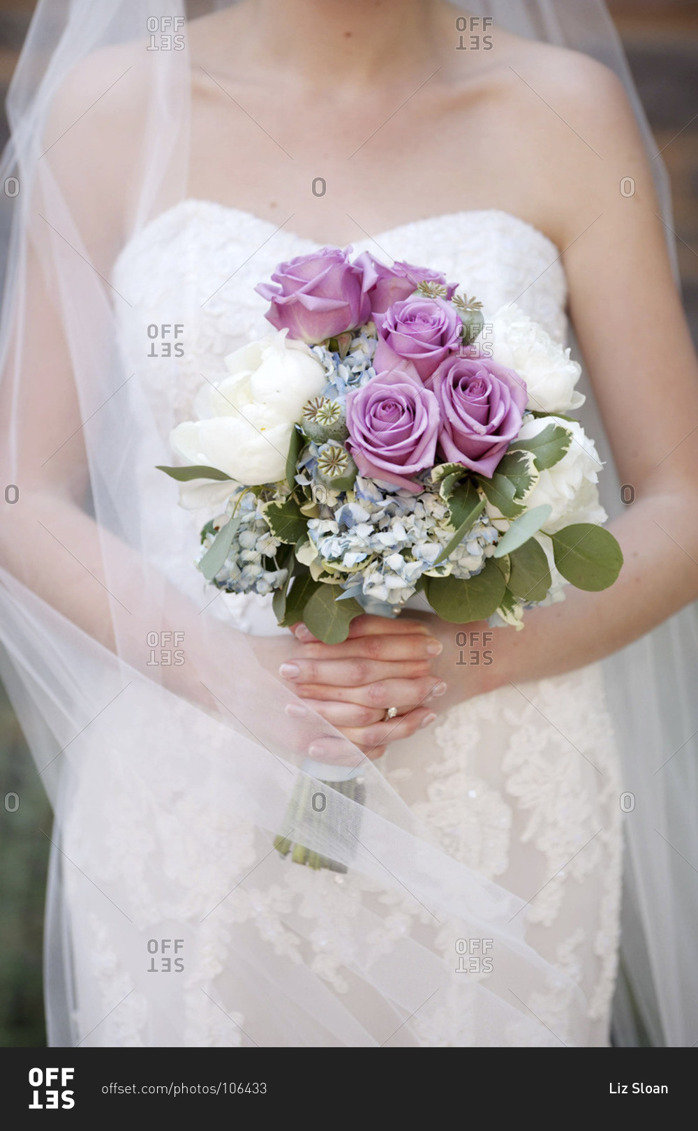 Mid section view of bride holding bridal bouquet