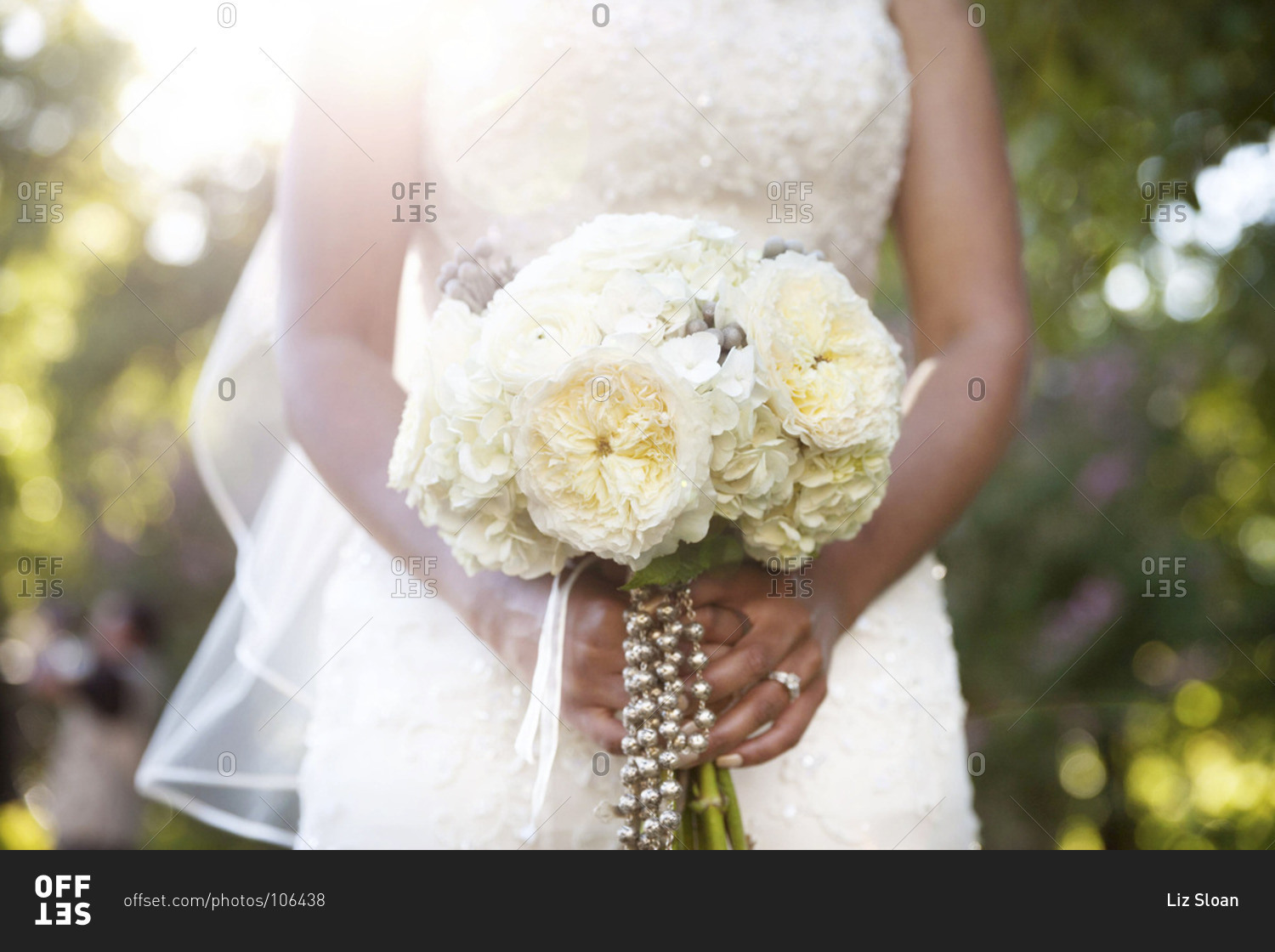 Mid section view of bride holding white bridal bouquet