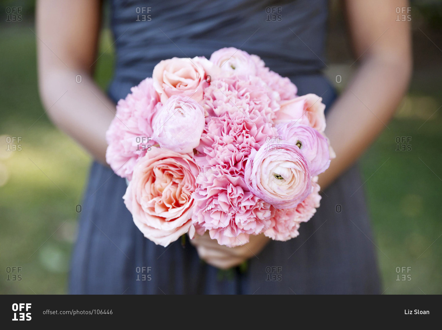 Mid section view of bridesmaid holding a pink variation bouquet