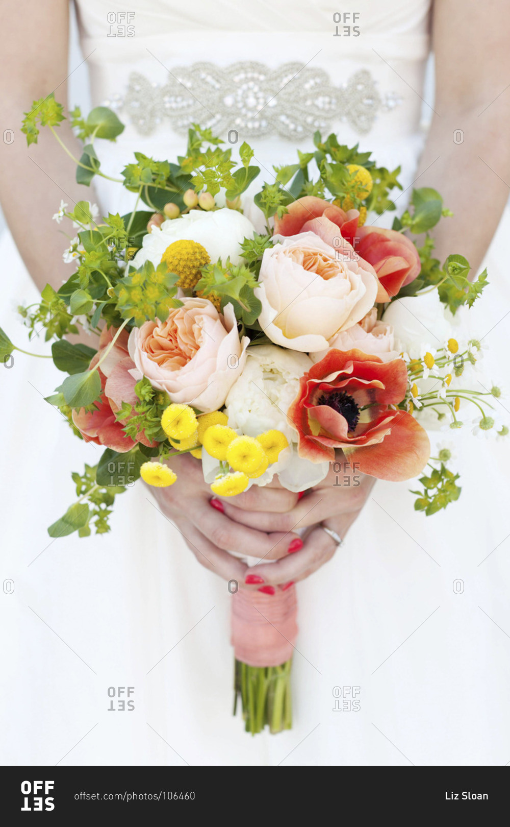 Mid section view of bride holding colorful bridal bouquet