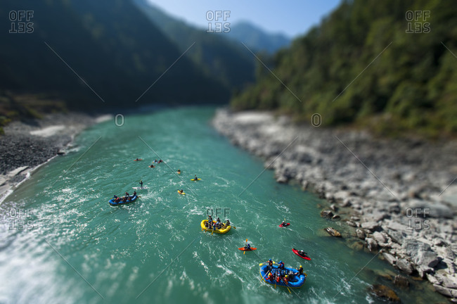 Rafts and kayaks drift down the Karnali river in west Nepal