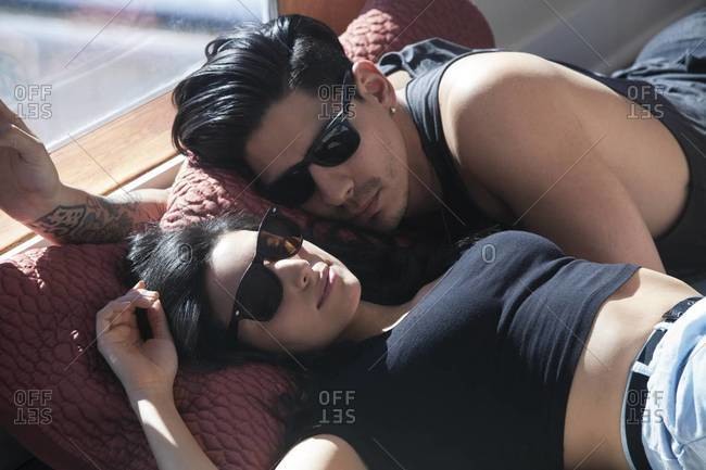 Young couple cuddling with sunglasses on