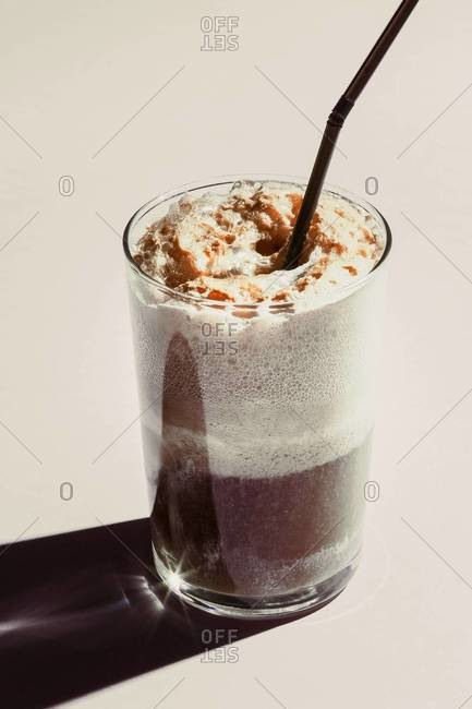 Frothy beverage with drinking straw