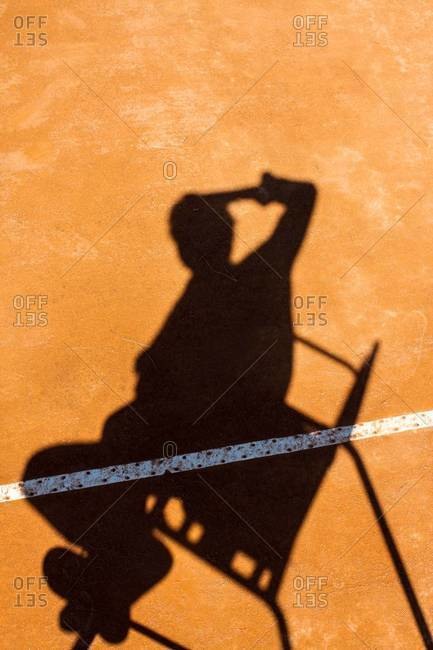 Shadow of tennis umpire