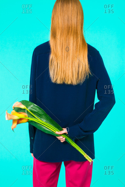 Back view of a woman holding an Calla Lily flower