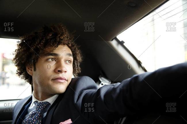 Young businessman looking out cab window