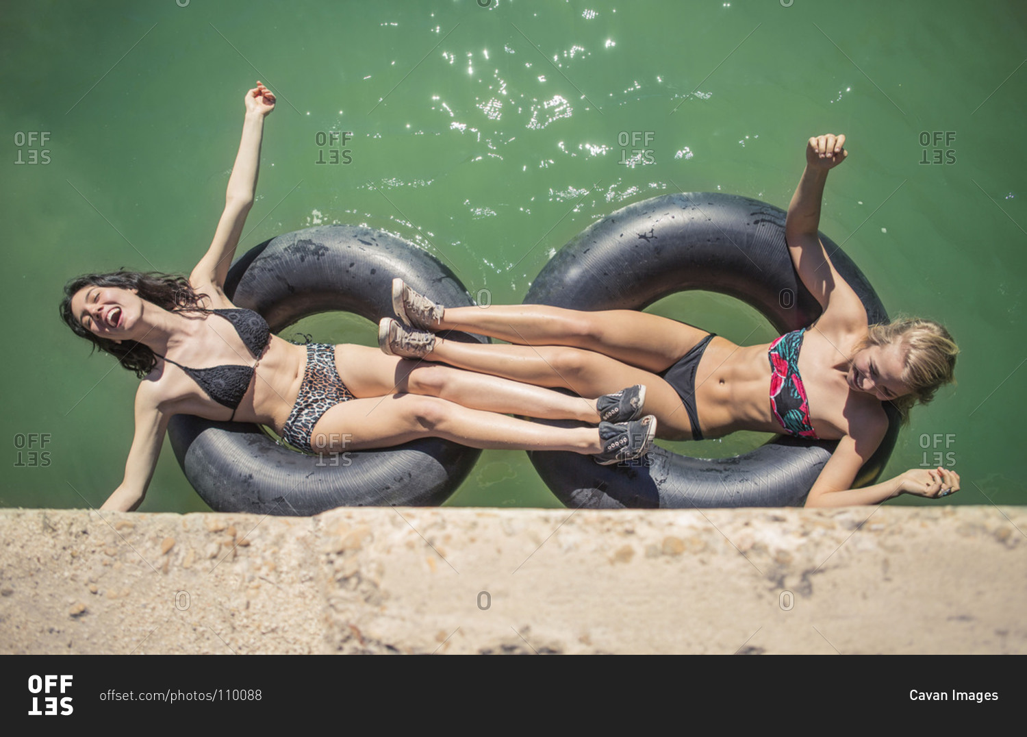 Two young woman floating in inner tubes