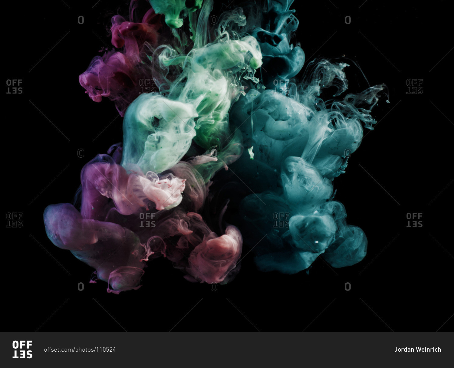 Purple, green, and blue smoke come together on a black background. stock  photo - OFFSET