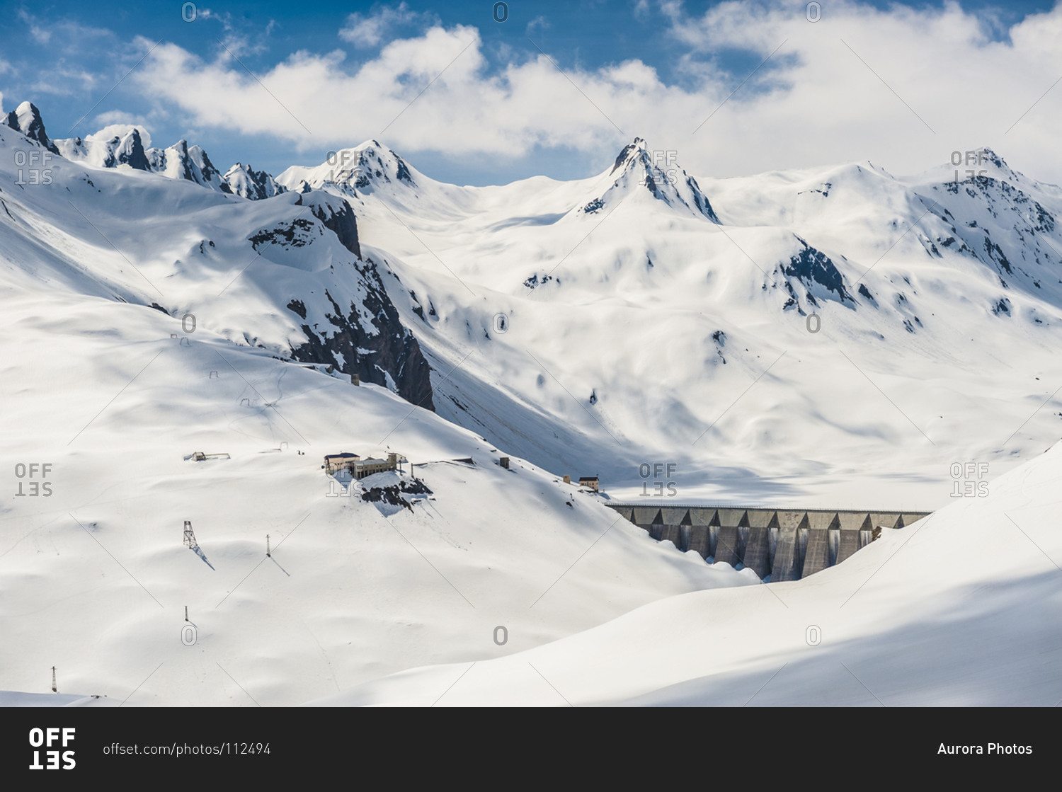 Dam for hydroelectric power production with snow-capped mountains in the background. Ossola, Italy