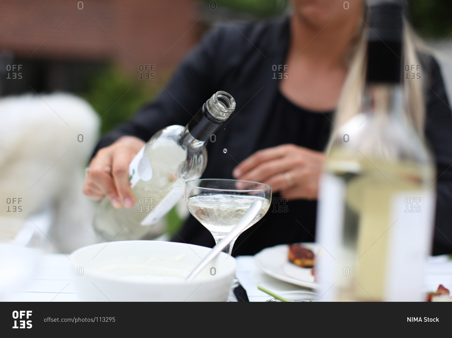 Woman about to pour white wine