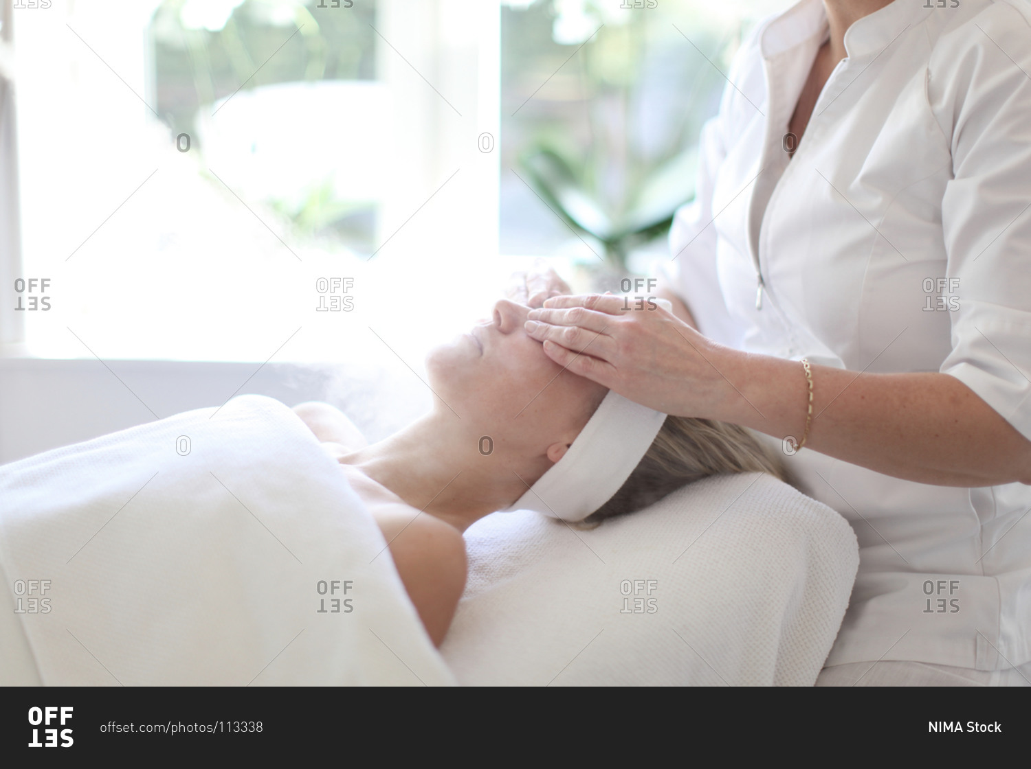 Beauty therapist giving calming healing face massage with face steam and aromatherapy mask