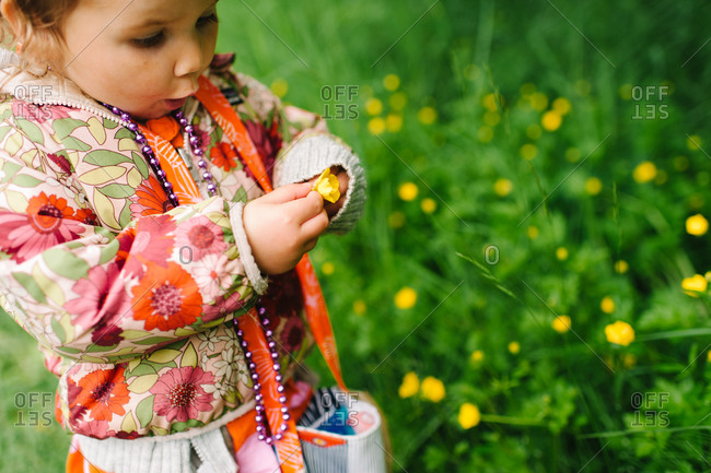 Little girl holding a yellow flower