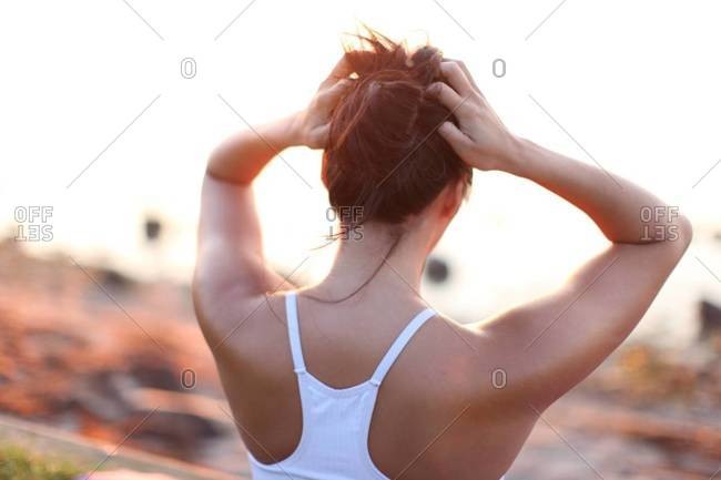 A Woman Tying Up Her Hair Stock Photo Offset
