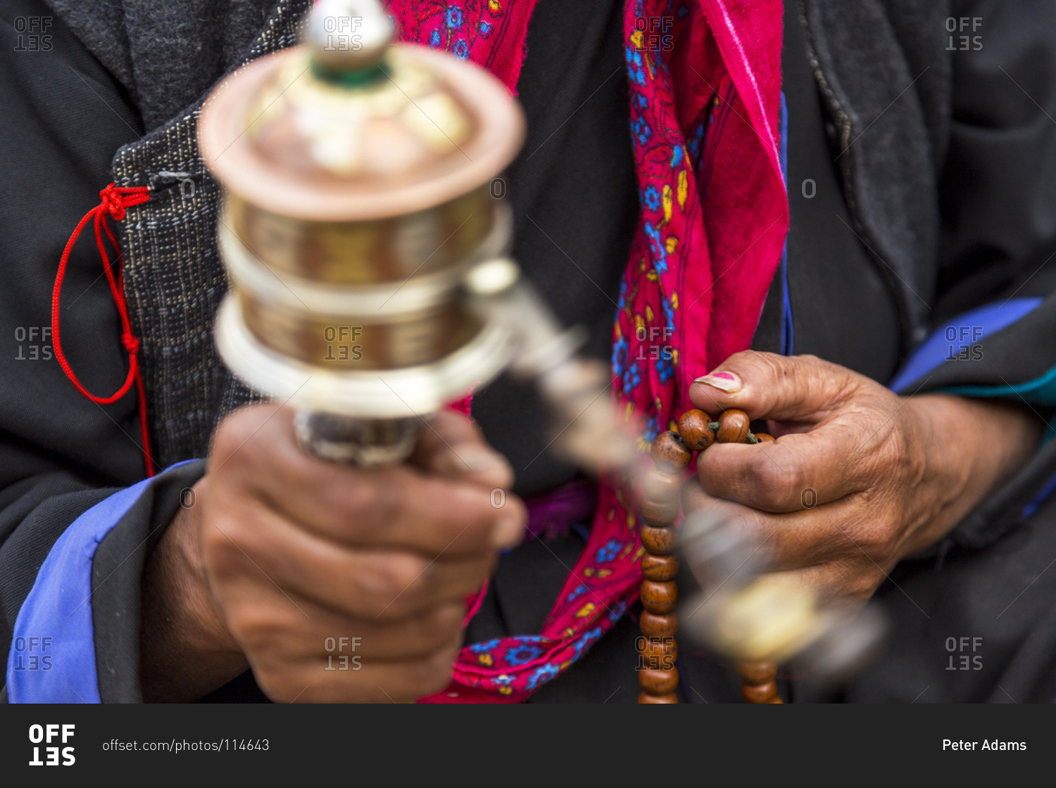 Close up of a Ladakhi woman holding prayer beads and prayer wheel