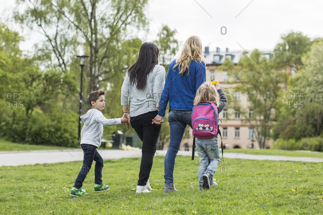 Rear view of female homosexual family walking in park