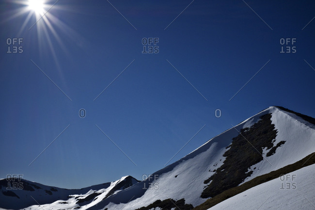 Sun over a snowy mountain peak