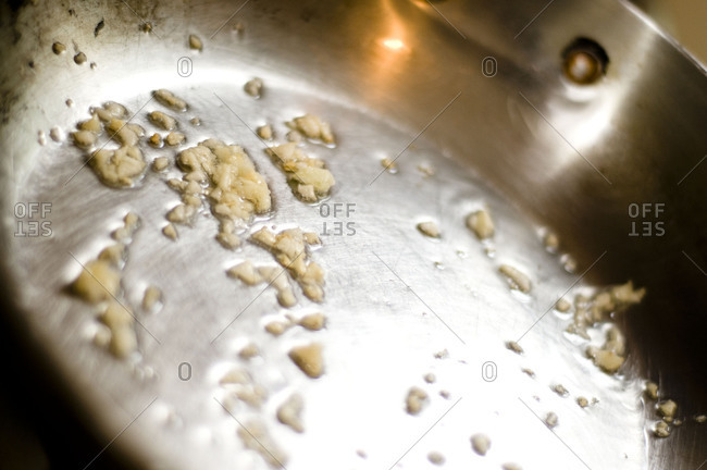 Close up of sauteing finely chopped garlic