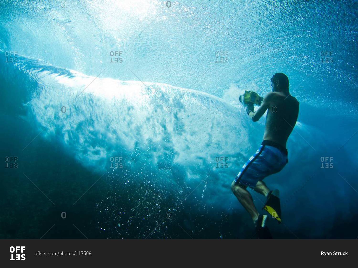 Man filming underwater at Teahupoo, Tahiti stock photo OFFSET