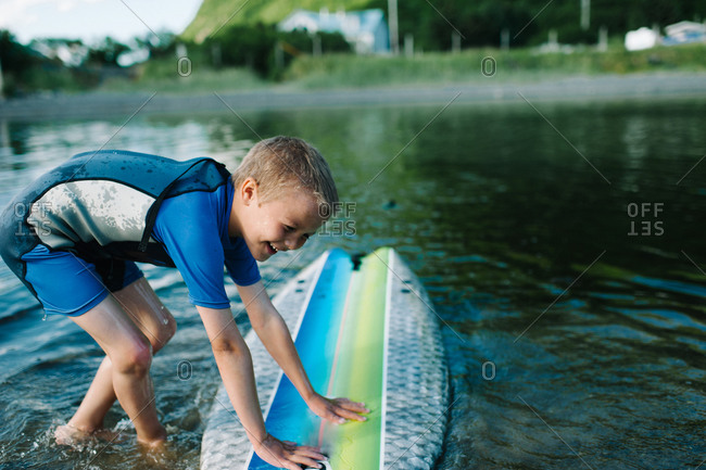 Boy leaning on a surfboard