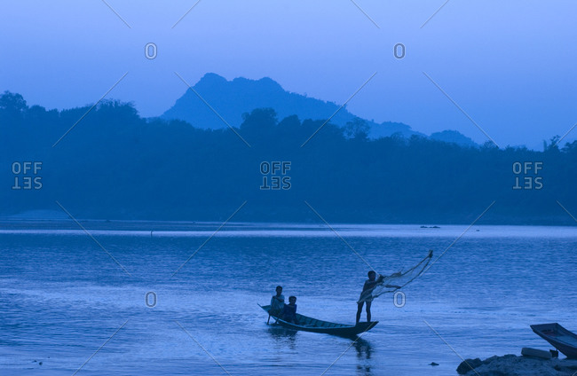 Children fishing on Mekong River at sunset in Luang Prabang, Laos