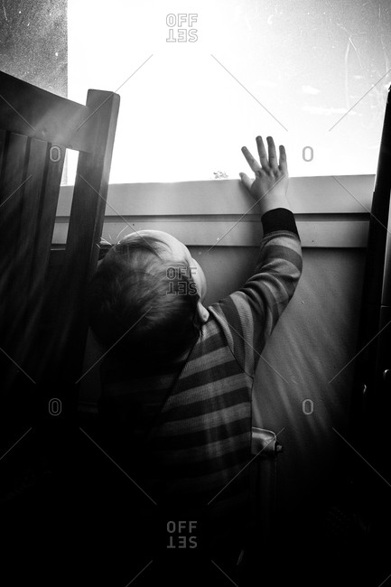 Boy reaching for a window