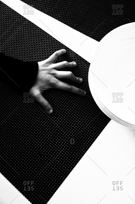 Overhead view of a hand on place mat