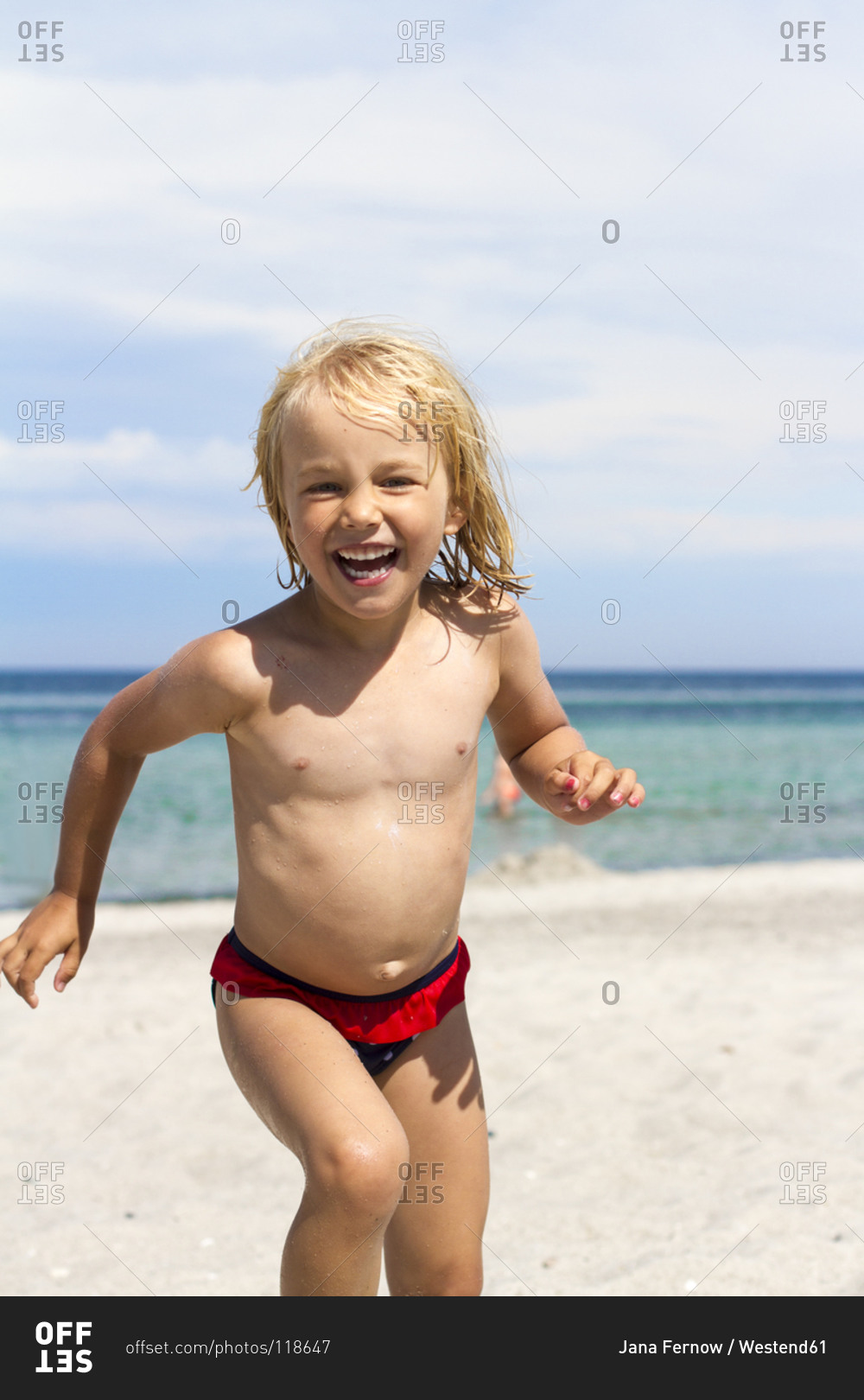 Portrait of a smiling little girl on the beach stock photo - OFFSET