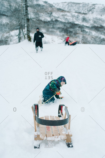 Child pulling a sled on snow