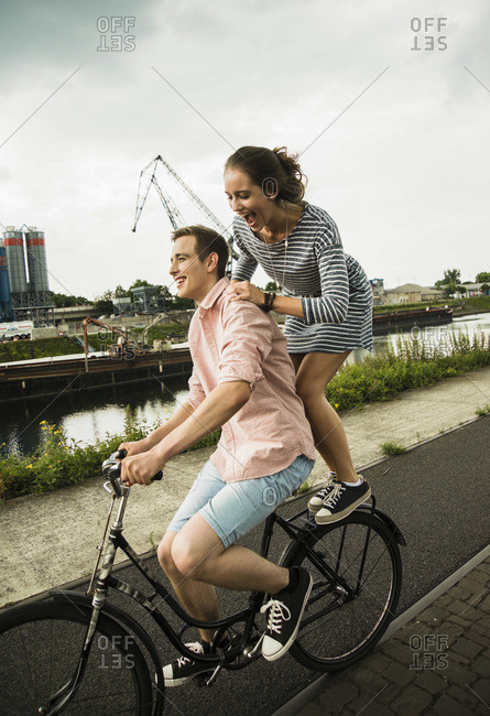 Young couple driving together on bicycle