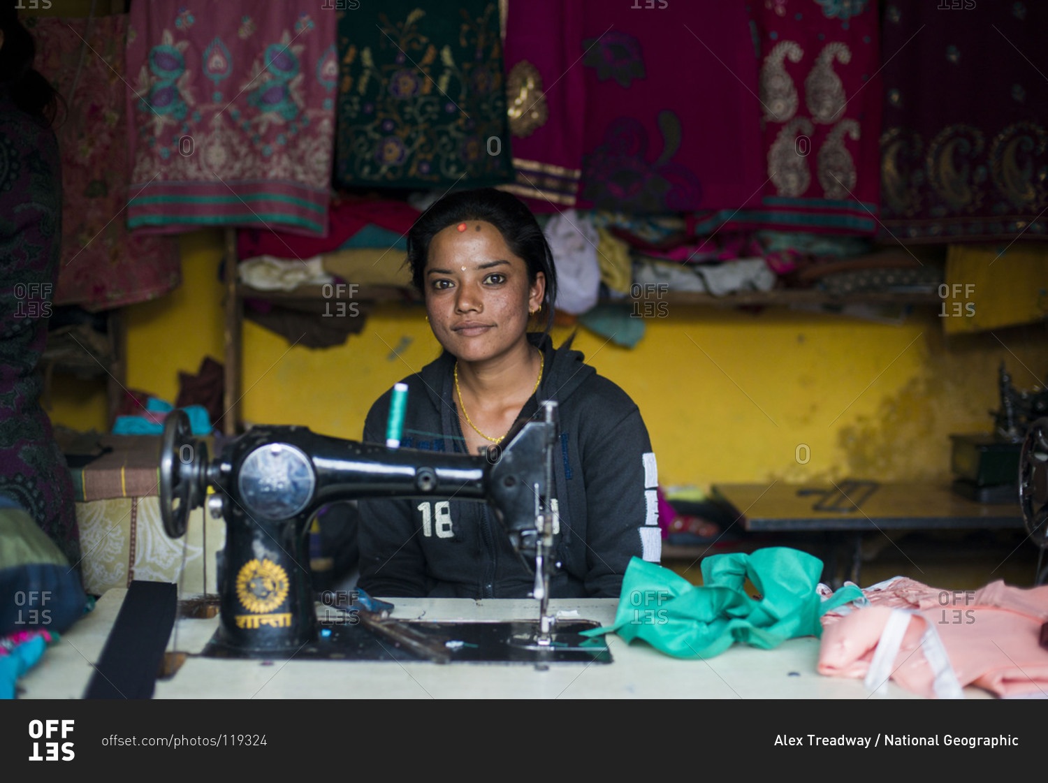 A woman works on a sewing machine in a village in Nepal stock photo